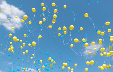 Yellow balloons in sky